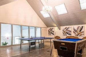 two ping pong tables in a room with windows at Haddon Grove Farm Cottages in Bakewell