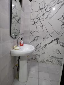 y baño con lavabo blanco y espejo. en Résidence Maty - 2 chambres salon en Grand Médina