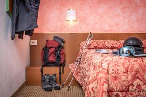 um quarto com um capacete e uma mochila ao lado de uma cama em Hotel Italo em Madonna di Campiglio