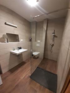 ein Bad mit einer Dusche, einem Waschbecken und einem WC in der Unterkunft Beach Home in Keszthely