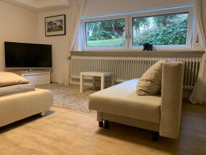a living room with a chair and a flat screen tv at Studio-Apartment Nähe Erlangen/Herzogenaurach in Großenseebach