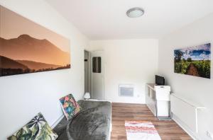 een woonkamer met een bank en schilderijen aan de muur bij Horizons Verts Appartement Cerisier in Puivert
