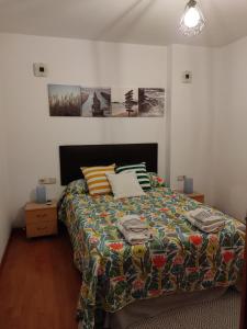 a bedroom with a bed with a colorful comforter at Apartamento Dúplex El Monumento in San Juan de Aznalfarache