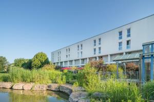 ein Apartmenthaus mit einem Fluss davor in der Unterkunft Best Western Parkhotel Weingarten in Weingarten
