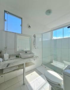 a white bathroom with a sink and a toilet at Pousada Solar da Ferradurinha in Búzios +35 photos