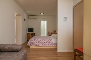 1 dormitorio con 1 cama y TV en Apartments Pasko, en Dubrovnik