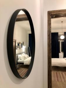 a mirror on a wall in a room with two beds at Park apartment in the heart of the city in Lviv