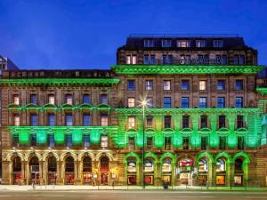 a building lit up green at night at ibis Styles Manchester Portland in Manchester