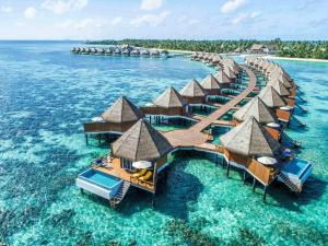eine Insel mit Bungalows über dem Wasser in der Unterkunft Mercure Maldives Kooddoo Resort in Gaafu Alifu Atoll