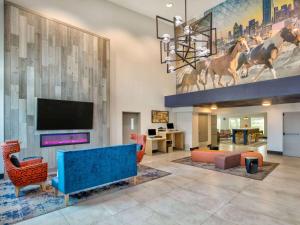 een woonkamer met een bank en een tv bij La Quinta by Wyndham Dallas - Las Colinas in Irving
