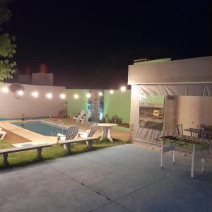 - une terrasse avec un banc et une piscine la nuit dans l'établissement COMPLEJO Aires del Ñapindá, à Paraná