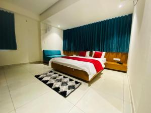 ein Schlafzimmer mit einem großen Bett und blauen Vorhängen in der Unterkunft Hotel Prime in Gandhinagar