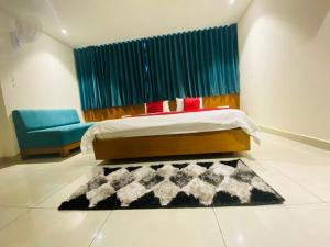 a bedroom with a bed and a couch and a rug at Hotel Prime in Gandhinagar