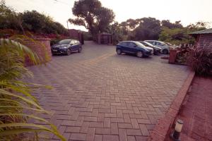 eine Gruppe von Autos, die auf einem Parkplatz geparkt sind in der Unterkunft La Serene Resort and Spa in Mahabaleshwar