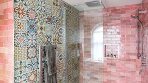 baño con ducha con azulejos en la pared en The Bear Hotel, en Wareham