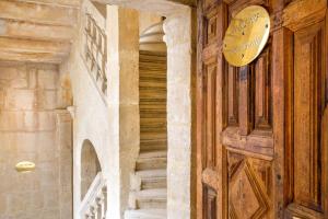 una puerta de madera con un cartel al lado de las escaleras en Best Western Marquis de la Baume en Nimes