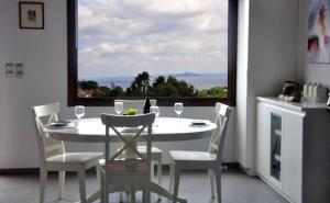 d'une salle à manger avec une table, des chaises et une fenêtre. dans l'établissement Magnolia Apartment, à vieille ville d'Alonissos