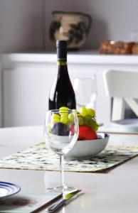 Una botella de vino sentada en una mesa con una copa de vino en Magnolia Apartment, en Centro histórico de Alónnisos 19 fotos más