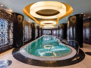 a swimming pool in a hotel with a ceiling at Swissotel Tallinn in Tallinn