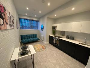 a kitchen with a blue couch in a room at Kempston Suites Liverpool Apartment 7 in Liverpool