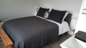 een slaapkamer met een groot bed met zwart-witte kussens bij Bed en Breakfast The Wooden Wall in Marum