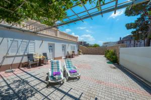two lounge chairs sitting on a patio with a table at Villa Borna Apartments with Free Parking in Dubrovnik