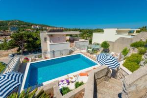 eine Villa mit einem Pool und einigen Stühlen in der Unterkunft Villa Borna Apartments in Dubrovnik