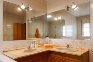 a bathroom with two sinks and a large mirror at Casa Fontanals in Pla del Panadés +42 photos