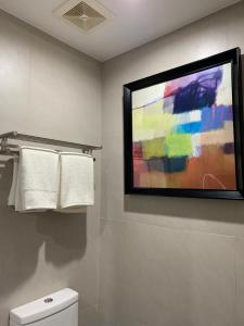 ein Badezimmer mit einem Fernseher an der Wand und Handtüchern. in der Unterkunft Club Aeon in Davao City + 45 Fotos