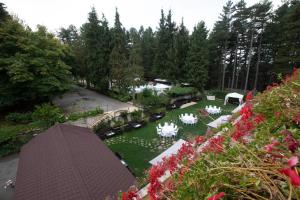 - une vue aérienne sur un jardin avec des tables et des chaises blanches dans l'établissement Parco dei Pini - Sila Wellness Hotel, à Taverna