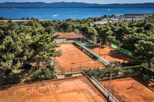 an overhead view of two tennis courts with trees at Bluesun Hotel Borak in Bol
