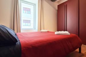 een slaapkamer met een rood bed en 2 handdoeken erop bij PORTA NUOVA - Casa Vacanze Ai Mille - 3 in Bergamo
