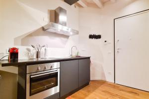 een keuken met een wastafel en een fornuis top oven bij PORTA NUOVA - Casa Vacanze Ai Mille - 3 in Bergamo