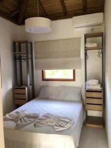 - une chambre avec un lit blanc et une fenêtre dans l'établissement Casa, 2 Suítes com Ar, Piscina a 400 mts Praia - Taipu de Fora, Barra Grande #4, à Marau