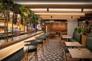 a restaurant with tables and chairs and a bar at Leonardo Hotel Chester in Chester