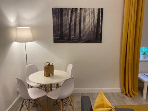 una mesa blanca y sillas con una bolsa. en Self-contained luxurious feel apartment, en Dunfermline