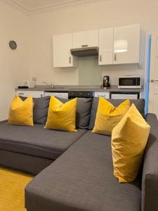 un sofá con almohadas amarillas en la cocina en Self-contained luxurious feel apartment, en Dunfermline