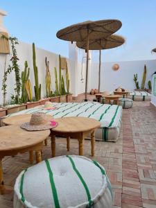 d'une terrasse avec des tables, des chaises et des cactus. dans l'établissement Riad Dar Rabiaa, à Rabat