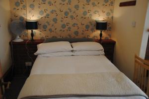a bedroom with a bed with two lamps on the wall at Ottery Tor in Stokeinteignhead