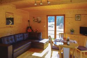 een woonkamer met een bank en een tafel bij Family Friendly Kraševec Lodge - Happy Rentals in Velike Bloke
