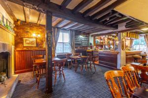 a restaurant with wooden tables and chairs and a bar at The Forest Lodge in Edwinstowe