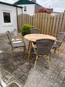 a table and chairs and a table and a fence at Hexenhäuschen Wankendorf in Wankendorf