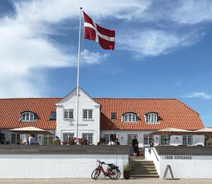 una bandera en un poste frente a un edificio en Fanø Krogaard, en Fanø