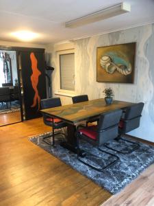 een eetkamer met een houten tafel en stoelen bij B & B Nomad in 't Zand