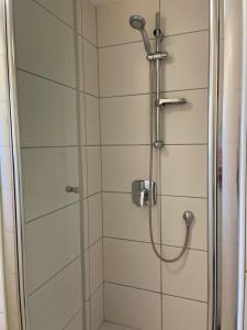 cabina de ducha con puerta de cristal en my Hostel Füssen, en Füssen
