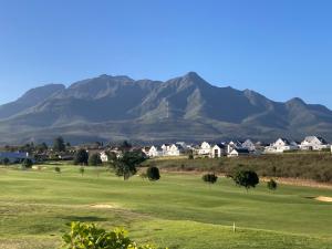 Blick auf einen Golfplatz mit Bergen im Hintergrund in der Unterkunft Golfers View @ Kingswood Golf Estate in George