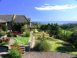 a house with a garden with a pond in the yard at The Bothy in Stonehaven