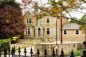 a large brick house with a fence in front of it at The Nook at Nydsley Hall - Featuring Patio & Hot tub in Pateley Bridge