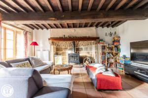 a living room with couches and a stone fireplace at Aux 2 Puys - Gîte "Le Lemptégy" in Saint-Priest-des-Champs