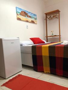 ジェリコアコアラにあるAmelinhas Houseのベッドルーム1室(カラフルな毛布付きのベッド1台付)